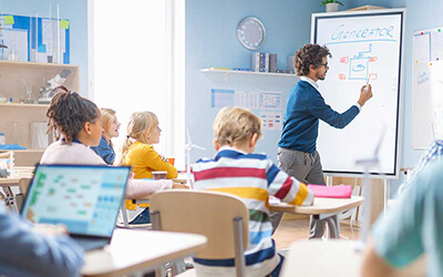 A teacher using a Data Projections portable display as a whiteboard to teach class