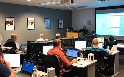 Data Projections teammates sitting in a classroom learning about the latest AV technology