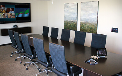 A conference room with a virtual meeting set up on the screen