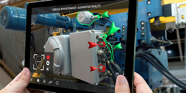 A pair of hands holding up a tablet to a piece of machinery and letting AR technology breakdown what parts of the machinery need to be fixed