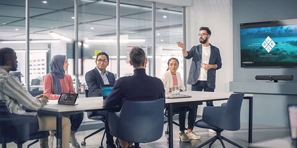 Young professionals in a conference room using the Creston Flex video conferencing solution