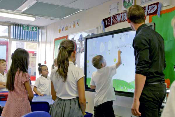 A teacher using a Data Projections portable display as a whiteboard to teach class