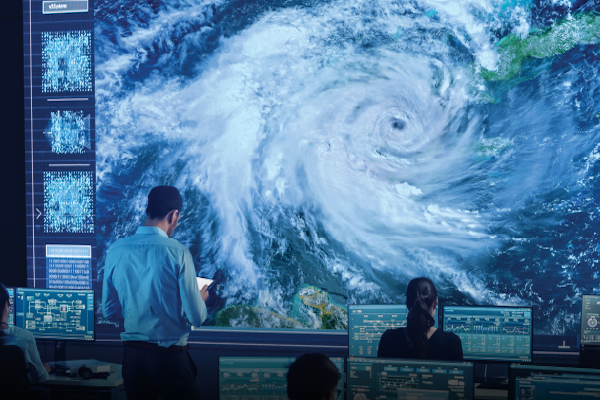 A weatherman looking at an incoming hurricane on a huge video wall from Data Projections