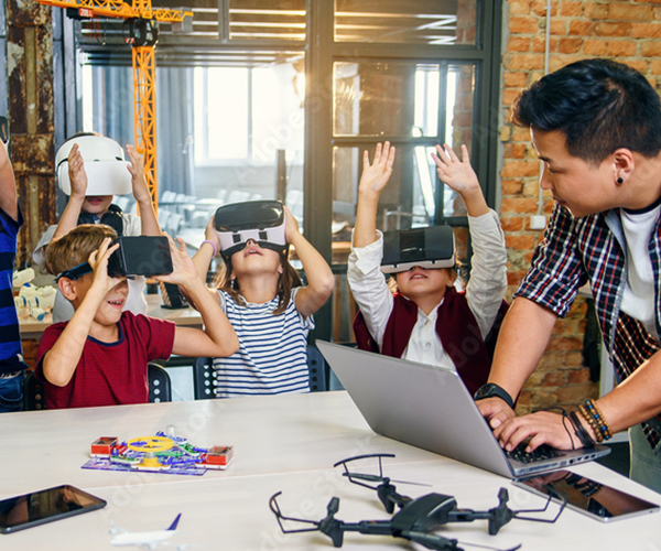 A man monitoring kids as they play with VR headsets