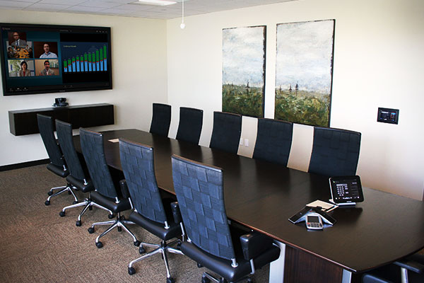 A conference room with a virtual meeting set up on the screen